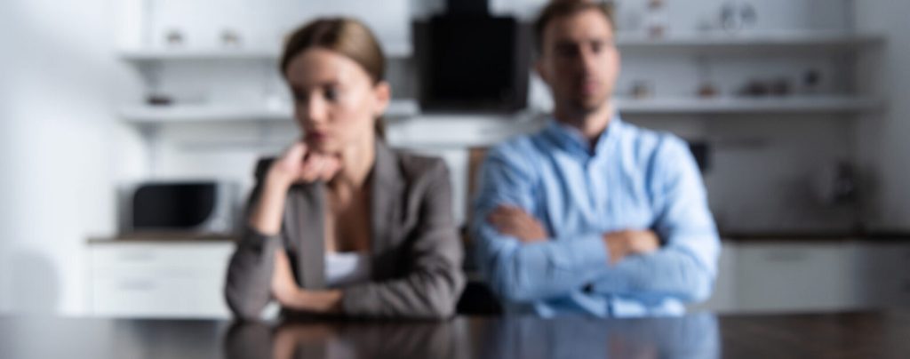 selective focus of couple sitting at table with divorce documents